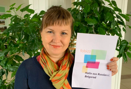 Lehrerin hält Schild hoch, auf dem